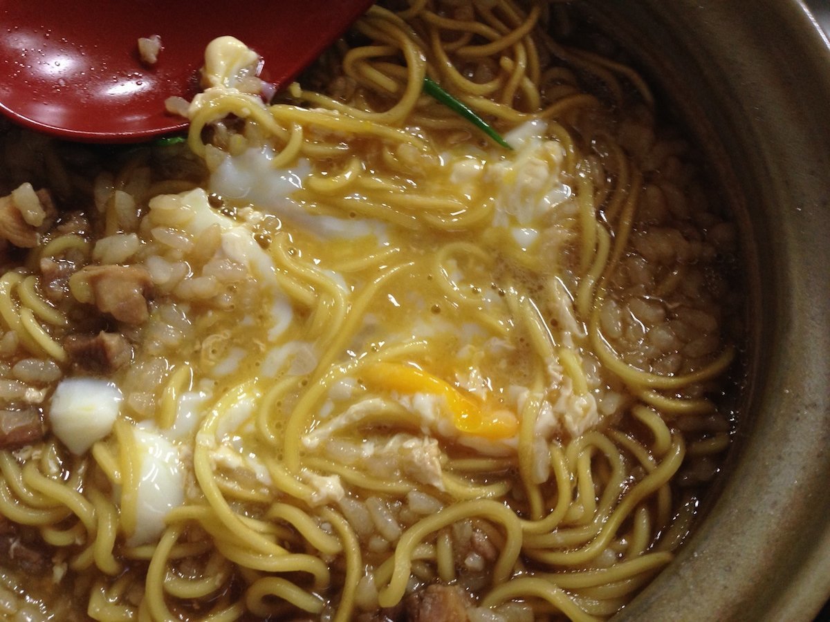 鍋焼きラーメンの生卵を崩す